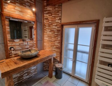 Lavabo de pierre posé sur un support en bois ancien de récupération de la chambre d'hôtes Roubion.