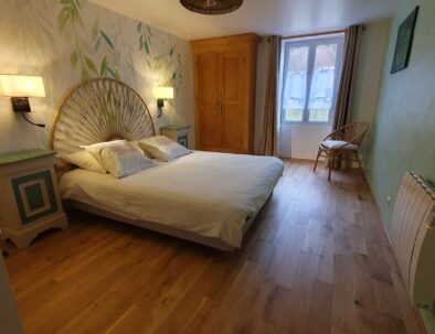 Chambre double orientée au sud avec armoire et fauteuil en rotin