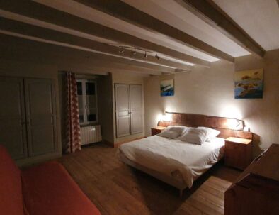 Suite parentale orientée au sud avec tête de lit en bois et placards
